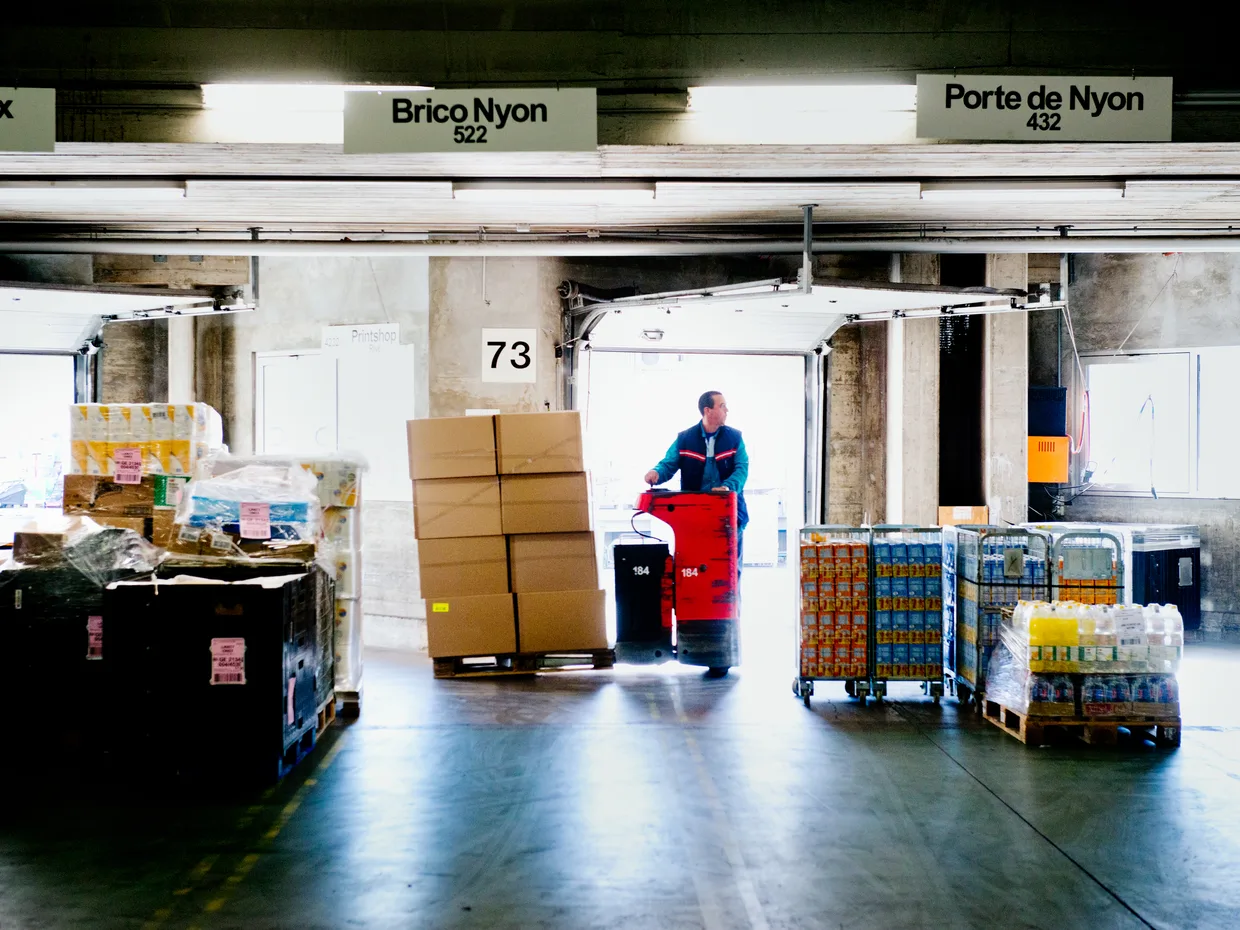 Plateforme logistique : manutentionnaire déplaçant des palettes de marchandises entre les quais