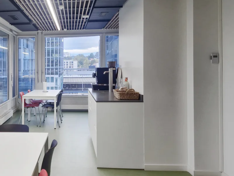 Espace cuisine et détente des bureaux de la FTI, avec coin repas et vue sur la ville